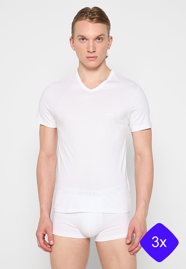 Weißes V-Ausschnitt-T-Shirt mit kurzen Ärmeln aus glattem Stoff, figurbetonter Silhouette, mit einem kleinen Logo auf der Brust. Kombiniert mit passenden weißen Unterhosen.