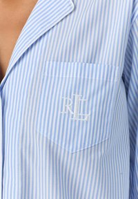 Blauw en wit gestreepte pyjama top met een notch kraag, zak met geborduurde initialen "RL," gladde stofstructuur.