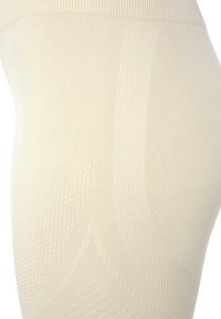 Beige naadloze legging met gestructureerde patronen en variërende brei-dichtheden, met een hoge tailleband en een gladde afwerking.