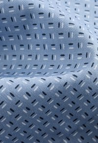 Lichtblauwe stof met een gestructureerd patroon van kleine, donkerblauwe en witte lijnen die in een raster zijn gerangschikt, en die een geweven ontwerp tonen.