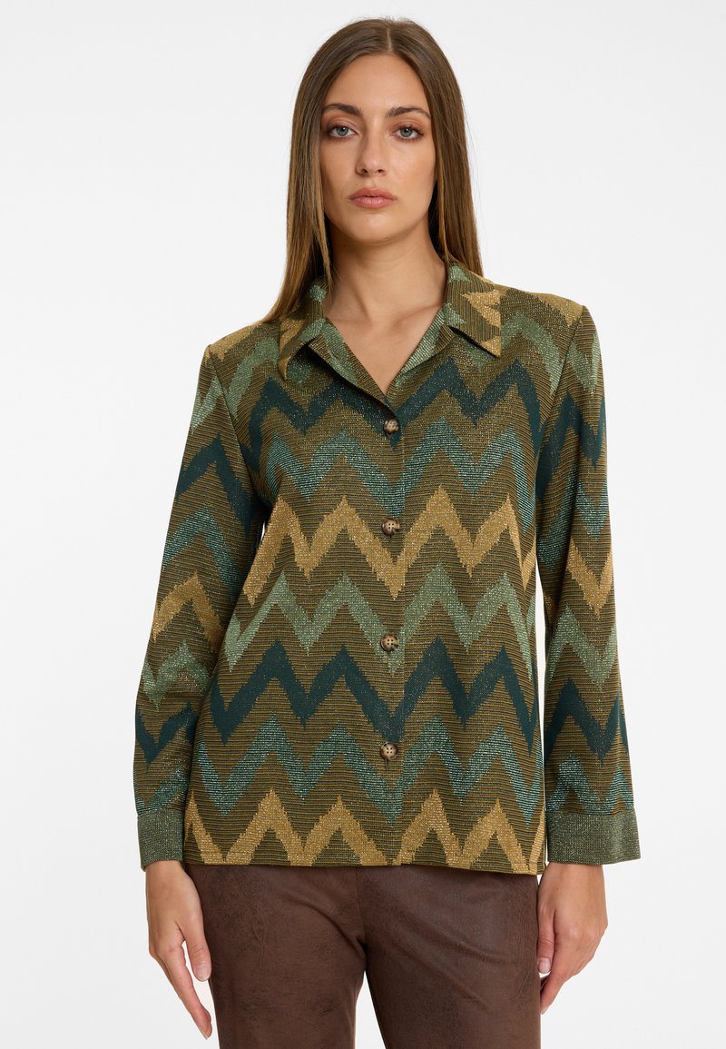 Hemd mit Knopfleiste und einem Zickzack-Muster in Grün, Gold und Dunkelblau. Aus strukturiertem Stoff, mit einem spitzen Kragen und langen Ärmeln.