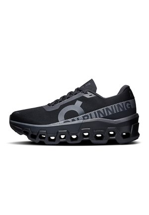 Černá atletická běžecká bota s šestihrannými výřezy na podrážce, reflexními prvky a značkovým textem na straně a jazyku.