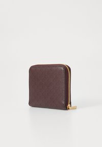 Burgundy leather wallet with a textured diamond pattern and gold zipper. Square shape, featuring a gold hardware logo tag on the side.