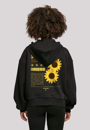 Black hoodie made of soft material featuring yellow sunflower graphics and text on the back, oversized fit with a drawstring hood.