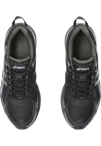 Černé sportovní boty vyrobené z syntetického materiálu, s texturovaným svrškem, šněrováním, polstrovaným kotníkem a bílým logem jako akcentem.