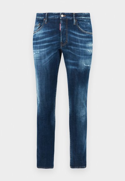 Jeans de ganga azul escuro com uma textura suave, design de perna ajustada, detalhes desgastados e lavagem desbotada nas coxas. Apresenta um fecho frontal com botão.