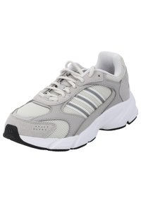 Scarpa sportiva grigia con tomaia in mesh e suede, dettagli bianchi, punta arrotondata, suola ammortizzata e strisce grigie ai lati. Suola in gomma nera.