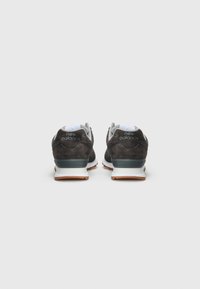 New Balance sneakers featuring a dark gray suede upper, white and blue mesh accents, and a rubber sole with a light brown tread.