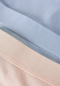 Drie stofstalen in lichtblauw, zachtblauw en zachte roze. Elk heeft een gladde textuur met gestikte randen en een uniform ontwerp.