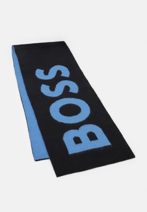 Écharpe pliée noire et bleue avec "BOSS" en grandes lettres bleues sur le côté noir, présentée sur un fond blanc uni.