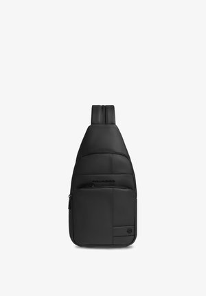 Mochila bandolera de cuero negro con una correa acolchada, bolsillo delantero con cremallera y pequeño logotipo en la esquina inferior derecha.