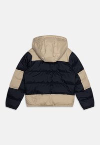 Giubbotto imbottito con un design a blocchi di colore beige e blu navy, dotato di cappuccio e orlo elastico. Realizzato in tessuto liscio e resistente.