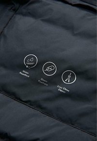 Czarna kurtka z tkaniny z wykończeniem hydrofobowym. Trzy białe ikony wskazują cechy: odporność na wodę, puch naturalny, łatwe zapinanie na zamek.