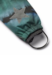 Groene en zwarte gepatronneerde zak met een grijze sterpatch, elastische sluiting aan de bovenkant en een zwarte handgreep. Glad, duurzaam stofmateriaal.