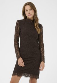 Rochie din dantelă maronie, cu mâneci lungi și decolteu înalt. Prezintă modele florale și un tiv cu margini ondulate, evidențiind o finisare texturată.