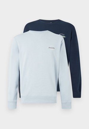 Deux sweatshirts à manches longues, un bleu clair et un bleu marine. Mélange de coton, col rond, poignets côtelés, petit logo sur la poitrine de chacun.