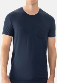 T-shirt in cotone blu navy a maniche corte, con scollo a girocollo e una tasca sul petto sinistro con silhouette quadrata.