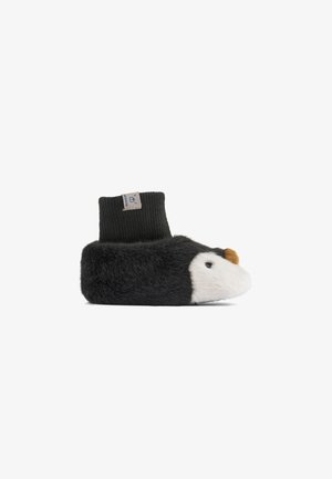 Svart och vit plyschbabyslippers formad som en pingvin med näbb i brunt och svart stickad ankelskaft med etikett.