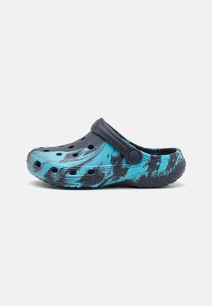 Sabot de couleur bleue et noire avec des perforations de ventilation, un design ergonomique et une sangle flexible pour un maintien sécurisé. Fabriqué en matériau léger.