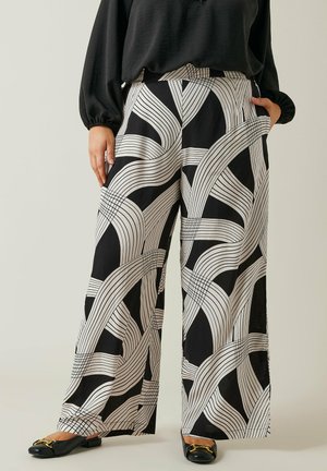 Zwart-witte brede broek met een lineair golfpatroon, gemaakt van zachte stof. Bevat zijzakken en heeft een ontspannen pasvorm.