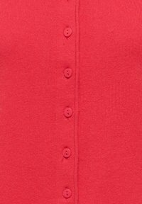 Cardigan rouge en tricot avec un devant boutonné comportant six boutons assortis et une texture lisse. Des coutures nettes sont visibles le long des bords.