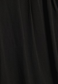 Tissu noir texturé avec un motif subtil et une drape douce, mettant en valeur une légère brillance et un mouvement dans le matériau.