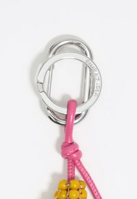 Keychain with a round silver metal clip, featuring a pink leather strap and a cluster of yellow beads at the end.