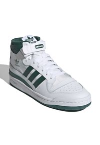 Hvide høj-top sneakers med grønne accenter, tre grønne striber på siden, tekstureret læder, polstret krave og velcro-rem.