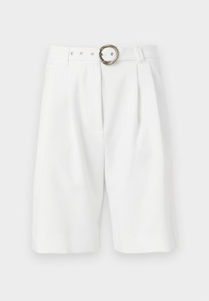 Pantalones cortos blancos a medida con un corte amplio, que presentan una hebilla metálica con patrón de cuerda, pliegues y un diseño limpio. Textura suave.