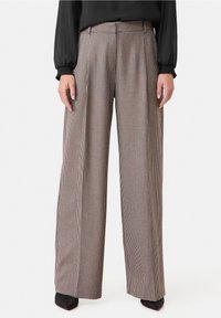 Breda byxor i en fabric med houndstooth-mönster i bruna och krämfärgade nyanser, med framvikningar och midjeband.