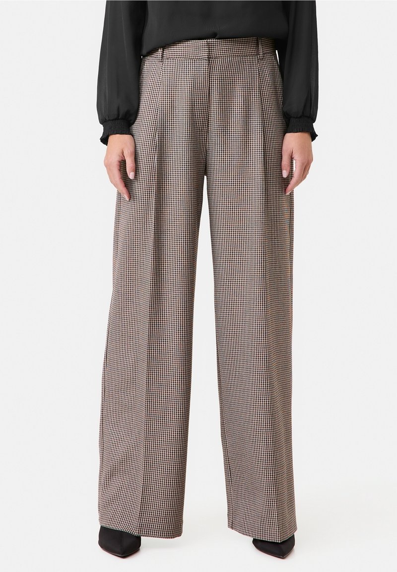 Breda byxor i en fabric med houndstooth-mönster i bruna och krämfärgade nyanser, med framvikningar och midjeband.