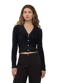 Cardigan nero e peloso con scollo a V, maniche lunghe e cinque bottoni gioiello sul davanti. Lunghezza cropped, texture morbida.