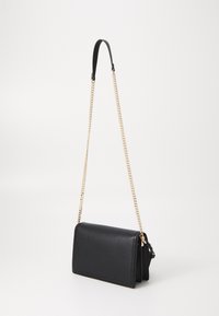 Borsa a tracolla in pelle nera con una texture liscia, tracolla in catena dorata e chiusura a pattina, caratterizzata da un design rettangolare minimalista.