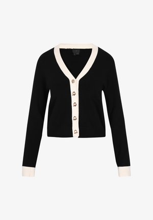 Melnā īsā kardigāna ar V veida kakla izgriezumu, krēmkrāsas pogu rindiņu un sešām zelta krāsas pogām. Ievērojamas garās piedurknes un krēmkrāsas akcenti.