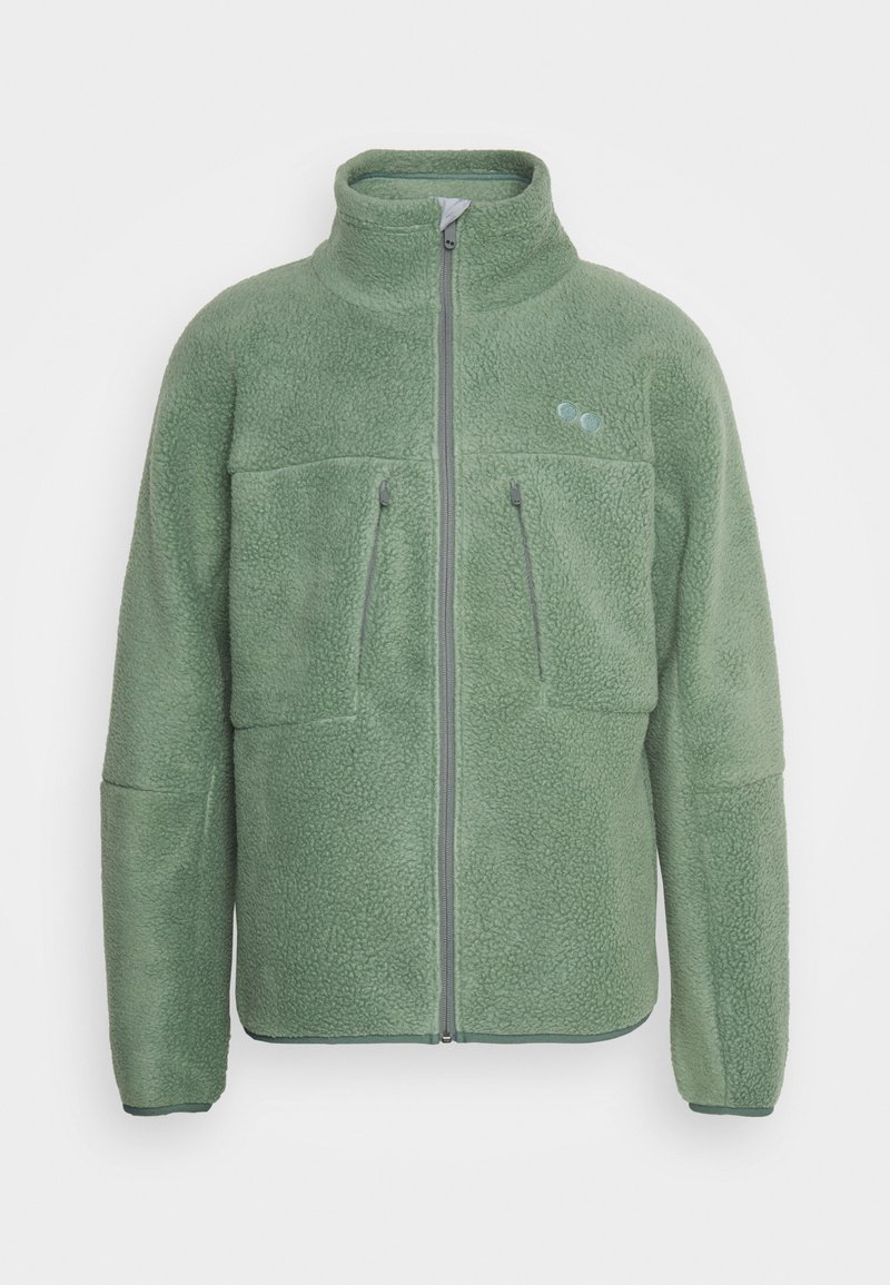 Veste en polaire de couleur verte discrète avec un col haut, deux poches zippées sur le devant, des détails de fermeture éclair grise et un tissu texturé.