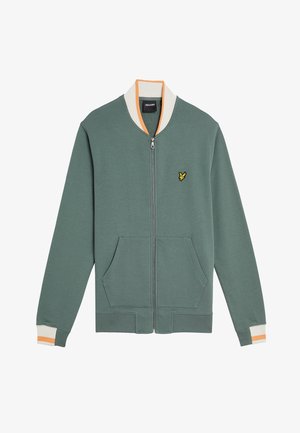 Groene zip-up jas met een geribde kraag, voorzien van oranje en crème accenten. Het heeft twee voorkeurszakken en een klein geel logo op de borst.