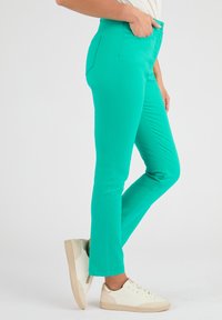 Pantaloni verdi a fit slim, realizzati in un tessuto morbido e elasticizzato. Presentano tasche laterali e una cintura per una vestibilità confortevole.