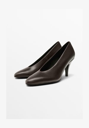 Bruna läderhögklackade skor med spetsig tå och djup vamp. Klackarna är smala och ungefär 7,5 cm höga.