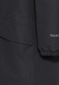 Giacca nera impermeabile con una superficie liscia, polsini elastici e una tasca laterale. Presenta il marchio "TEXAPORE" in grigio chiaro sulla manica.