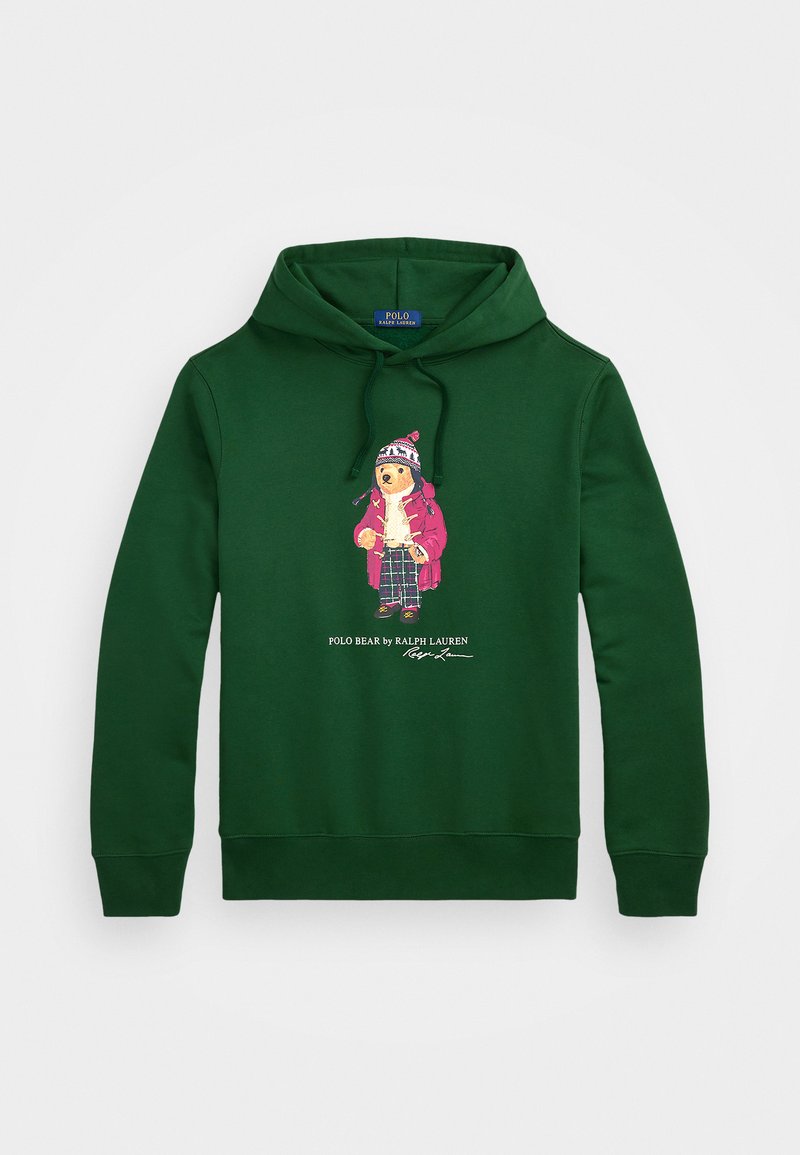 Sudadera de algodón verde con un gráfico de un oso vestido, con un gran bolsillo frontal y capucha con cordón. Texto del logo debajo del diseño.