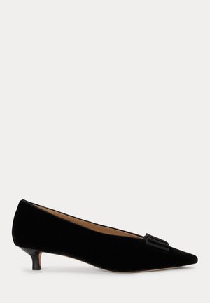 Chaussure femme en daim noire à talon bas, bout pointu, avec un petit nœud décoratif à l'avant et une doublure intérieure beige.