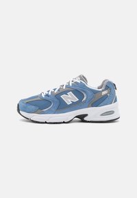 Chaussure de course en daim bleu et maille avec des accents gris, des lacets blancs et une semelle en caoutchouc noire. Présente le logo "N" et le marquage "ABZORB".