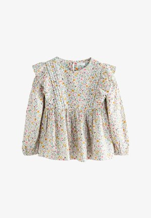 Balta auduma krekls ar ziedu rakstu un garām piedurknēm, ar viļņotām plecu akcentiem, savilktu jostu un košām rozā, dzeltenām un zaļām ziedu apdrukām.