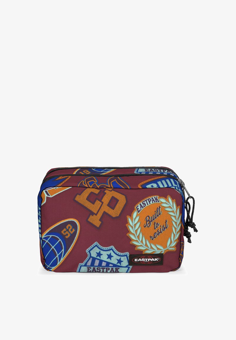 Punainen kangaspussukka, jossa on erilaisia palasia ja logoja. Ominaisuuksiin kuuluu kaksi vetoketjua ja teksturoitu pinta. Etupuolen brändäys sisältää "Eastpak" ja "Built to resist."