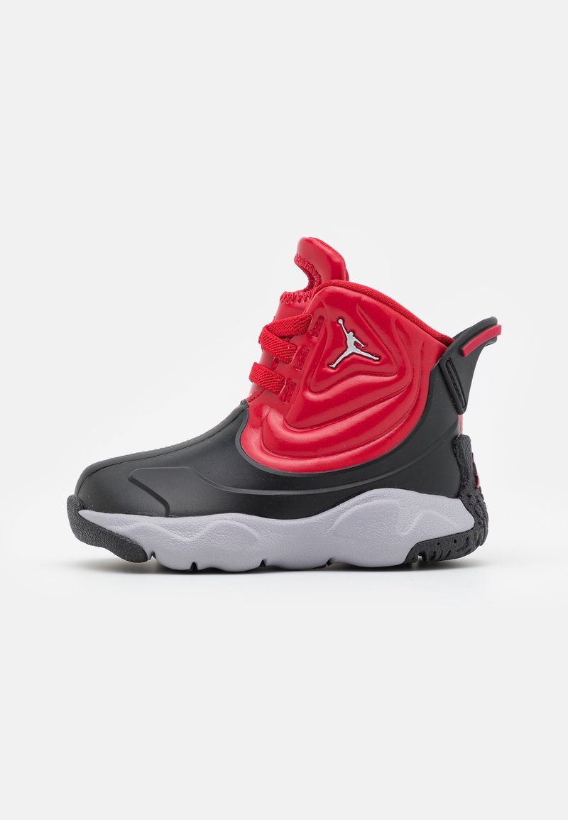 Chaussure de sport montante avec base noire, partie supérieure rouge, lacets rouges, semelle blanche et logo Jumpman argenté sur le côté.