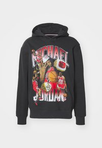 Felpa nera con cappuccio e stampa grafica di un giocatore di basket. Caratterizzata da un bold "Michael Jordan" e da vivaci immagini sportive in rosso e giallo.