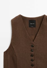 Brun ärmlös linnelinne med V-ringning, försedd med fem svarta knappar och en etikett med texten "Massimo Dutti" på insidan.