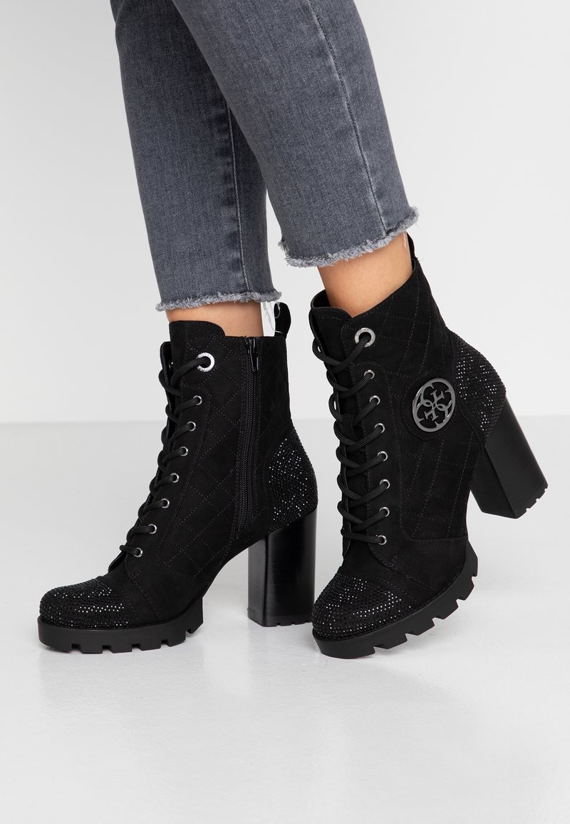 Stivaletti neri con lacci, in cima con una parte superiore in suede trapuntato, punta decorata con strass e tacco ampio. Presentano una zip laterale.