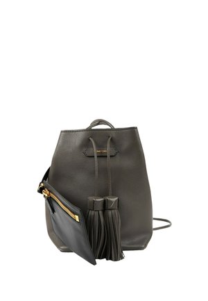 Sac à dos en cuir noir avec cordon, deux pompons et une petite pochette noire attachée avec une fermeture éclair dorée.