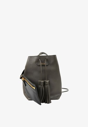 Sac à dos en cuir noir avec cordon, deux pompons et une petite pochette noire attachée avec une fermeture éclair dorée.